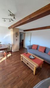 a living room with a blue couch and a table at Am Hohestein in Briedeler Heck