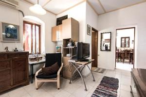 a living room with a television and a desk with a chair at Falasarna Lardas House in Falasarna