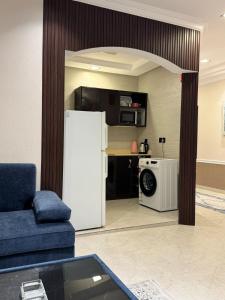a kitchen with a white refrigerator in a living room at قصر الروابي للشقق المخدومة اقتصادي in Riyadh +64 photos