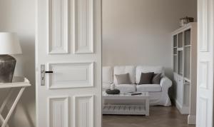 a white living room with a couch and a door at von Deska Townhouses - White House in Hamburg