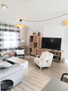 a living room with white furniture and a flat screen tv at House with 5 bedrooms and HOT TUB in Saint Cyprien Plage