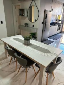 a dining room table with chairs and a kitchen at Apartamento Piratuba Alegria, 104 in Piratuba