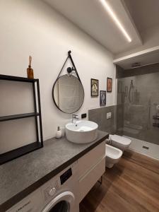 a bathroom with a sink and a toilet and a mirror at Gemmas home in Uboldo +18 photos