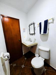 a bathroom with a toilet and a sink at Hotel Villa Esmeralda in Tuxtla Gutiérrez