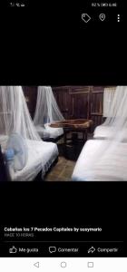 una foto di una camera da letto con due letti con zanzariere di Cabaña la envidia a Santa María Huatulco