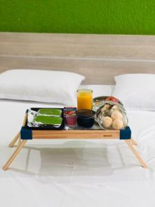 a tray with food and drinks on a bed at HOTEL E POUSADA ISIS in São Pedro
