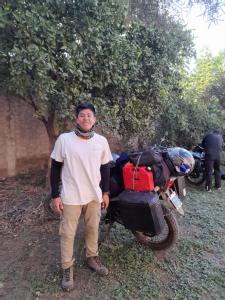 un hombre está parado frente a una motocicleta en Hostal, La Casa del Patio, en Bahía Blanca