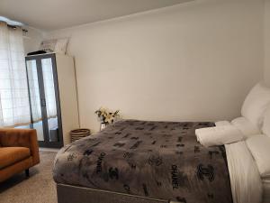 a bedroom with a large bed and a chair at Dmltd in Northampton