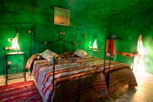 zieloną sypialnię z dużym łóżkiem w obiekcie Hotel Cueva Tardienta Monegros-Adults Only w mieście Tardienta +37 zdjęć