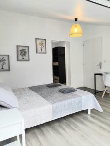 a white bedroom with a large bed and a desk at House with 5 bedrooms and HOT TUB in Saint Cyprien Plage