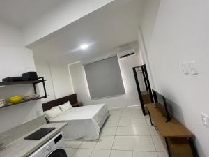 a small white room with a bed and a window at Condo ipanema 209 in Rio de Janeiro