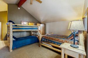 a bedroom with two bunk beds and a table with a lamp at Stedman Cabin in McCall