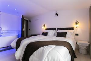a bedroom with a large bed and a bath tub at Aparthotel Dei Mercanti in Milan