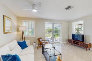 een woonkamer met een witte bank en een tv bij Lemon Bay Escapade in Englewood