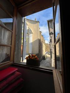 a window view of a street with a bowl of fruit at Maison de village in Silvareccio +2 photos