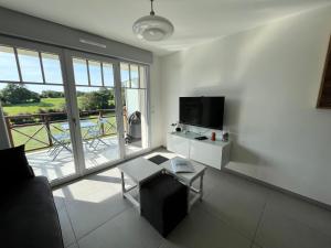 un salon avec un canapé, une télévision et une table dans l'établissement Appt avec balcon St Valery / Somme parking privatif 3/4 pers, à Saint-Valery-sur-Somme