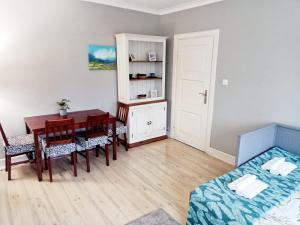 a room with a table and a bed and a dining room at Brick Lane Apartment in Gdańsk