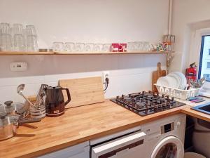 a kitchen with a stove top oven next to a washing machine at Brick Lane Apartment in Gdańsk