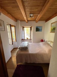 a bedroom with a bed in a room with wooden ceilings at Maison de village in Silvareccio