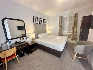 a hotel room with a large bed and a mirror at Carlisle Station Hotel, Sure Hotel Collection by BW in Carlisle