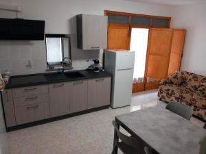 a kitchen with a refrigerator and a table and a couch at Antares in Isnello