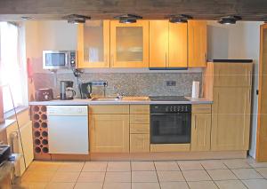a kitchen with wooden cabinets and a stove top oven at Santa Maria in Nettersheim