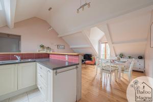 eine Küche mit weißen Schränken und einem Tisch mit Stühlen in der Unterkunft Le Rêve de Fantasia - Enchantement à Disneyland in Magny-le-Hongre + 4 Fotos