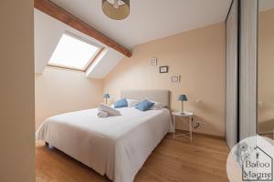 ein Schlafzimmer mit einem weißen Bett und einem Fenster in der Unterkunft Le Rêve de Fantasia - Enchantement à Disneyland in Magny-le-Hongre