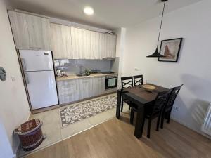 a kitchen with a dining table and a refrigerator at Apartman Pionir in Sarajevo