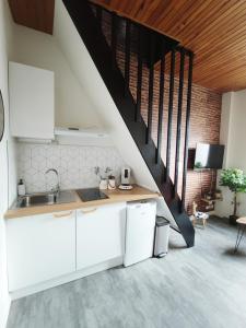 a kitchen with white cabinets and a staircase at Ô petit cocon in Albi