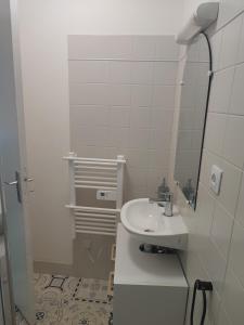 a white bathroom with a sink and a mirror at Ô petit cocon in Albi