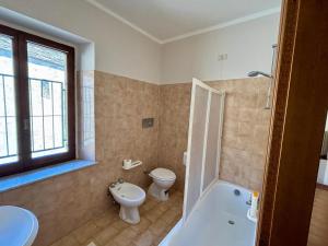 a bathroom with a toilet and a tub and a sink at Il vecchio convento in Vagli di Sotto +9 photos