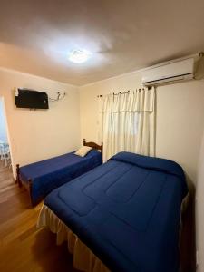 a bedroom with two beds and a tv on the wall at Shanti Loft in San Juan