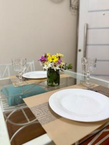 a table with plates and a vase of flowers on it at Shanti Loft in San Juan