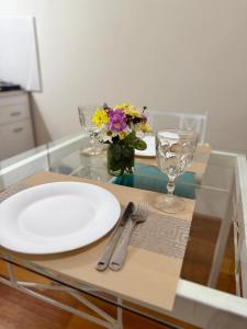 a glass table with a plate and a vase of flowers at Shanti Loft in San Juan