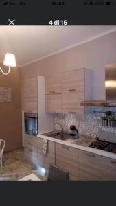 Una cocina con gabinetes de madera y encimera. en Casa Lella, en Policoro