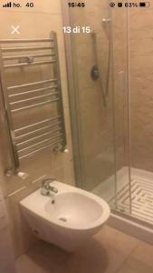 Un baño con lavabo blanco y ducha. en Casa Lella, en Policoro 10 fotos más