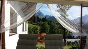twee stoelen voor een raam met bergen bij Haus Izabella in Filzmoos