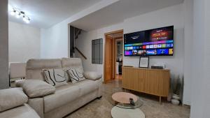 ein Wohnzimmer mit Couch und Flachbildfernseher in der Unterkunft Apartamentos Maria Cristina con parking gratis in Córdoba