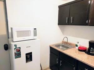una cocina con un microondas encima de un refrigerador en Cómodo departamento 2 cerca del centro de gobierno , CAS, Consulado , CRIT, en Hermosillo