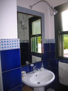 une salle de bains avec un lavabo et un miroir dans l'établissement Baglio La Luna - B&B, à San Vito Lo Capo