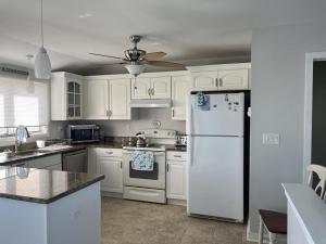 a kitchen with white cabinets and a white refrigerator at Pavloski in Beach Haven