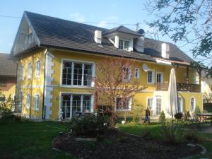 uma casa amarela com uma pessoa à frente dela em Landhaus Ferk em Unterburg am Klopeiner See