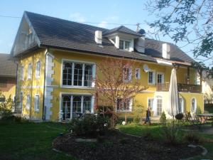 a yellow house with a person standing in front of it at Landhaus Ferk in Unterburg am Klopeiner See