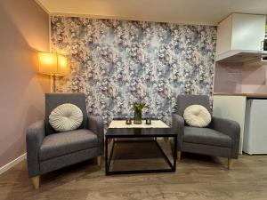 two chairs and a table in front of a wall at Cozy Apartment in Ålesund
