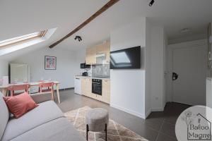 ein Wohnzimmer mit Couch und Küche in der Unterkunft Hercule - Séjour héroïque à Disneyland Paris in Magny-le-Hongre + 5 Fotos