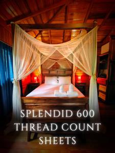 a bed with two towels sitting on top of it at The River House - Upscale Lodge in Puerto Quito +22 photos
