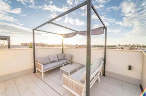 a balcony with a couch and a table at Luxury Penthouse - Rooftop Pool - 100m to the Sea in Torrevieja
