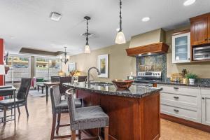 a kitchen with a large island in the middle at Solara Getaway 2BR Condo with Pool - Hot Tub - Gym - Spa in Canmore