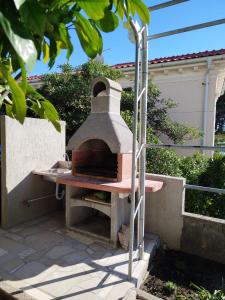 a pizza oven sitting on top of a patio at Cute apartment Arba in Rab